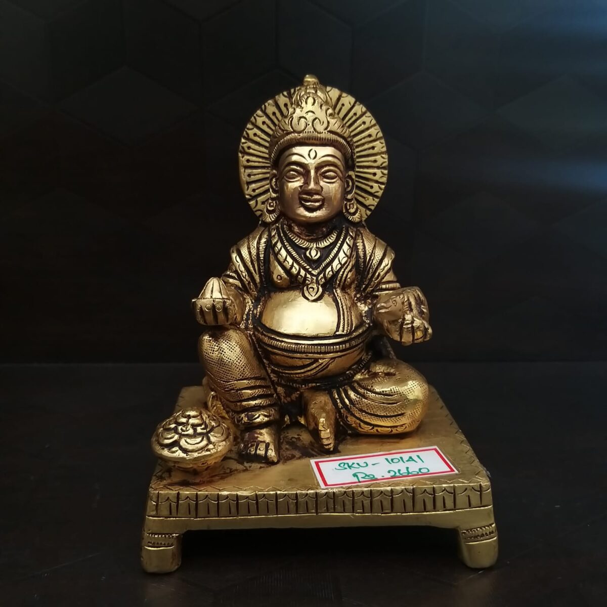 Brass Kuberar sitting on a Base Idol